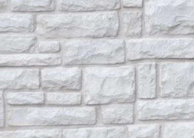 Light gray stone wall with rectangular and square stones arranged in a staggered, brick-like pattern.