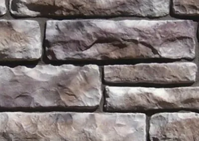 Close-up of a textured stone wall with uneven, stacked rectangular stones.