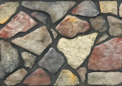 Irregularly shaped, multicolored stones set in dark mortar, forming a rustic stone wall pattern.