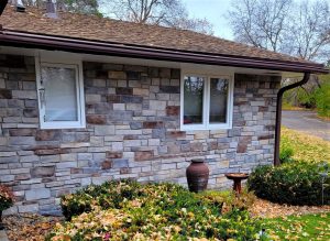 Quarry Blend – Blue Ridge Stone house wall with two windows, an urn, birdbath, and shrubs covered with fallen autumn leaves.