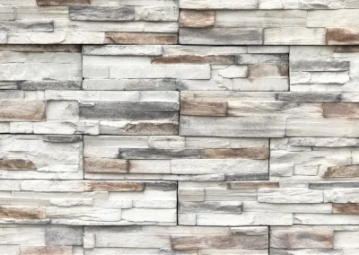White and beige stacked stone wall with varying rectangular stone shapes and subtle gray accents.