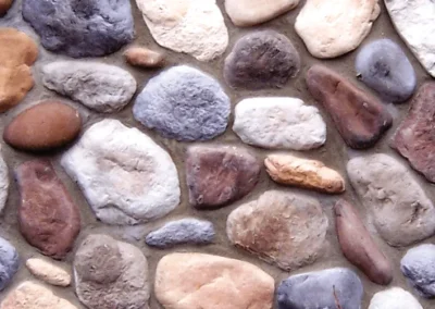 A close-up of a stone wall with various shapes and colors of rocks set in mortar.