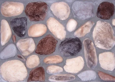 A variety of smooth, multicolored stones arranged in a flat rectangular pattern, embedded in gray cement.