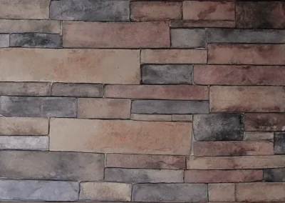 Stone wall with rectangular bricks in various shades of beige, gray, and brown, arranged in a pattern.