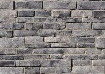 Gray stone bricks arranged in a horizontal pattern, forming a textured wall.