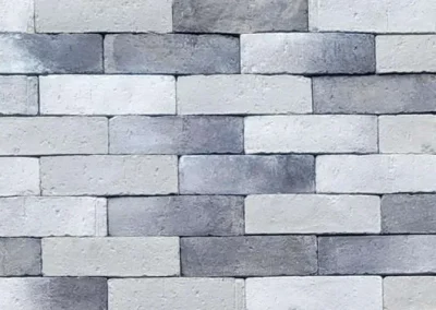 Gray and white rectangular bricks arranged in a staggered horizontal pattern on a wall.