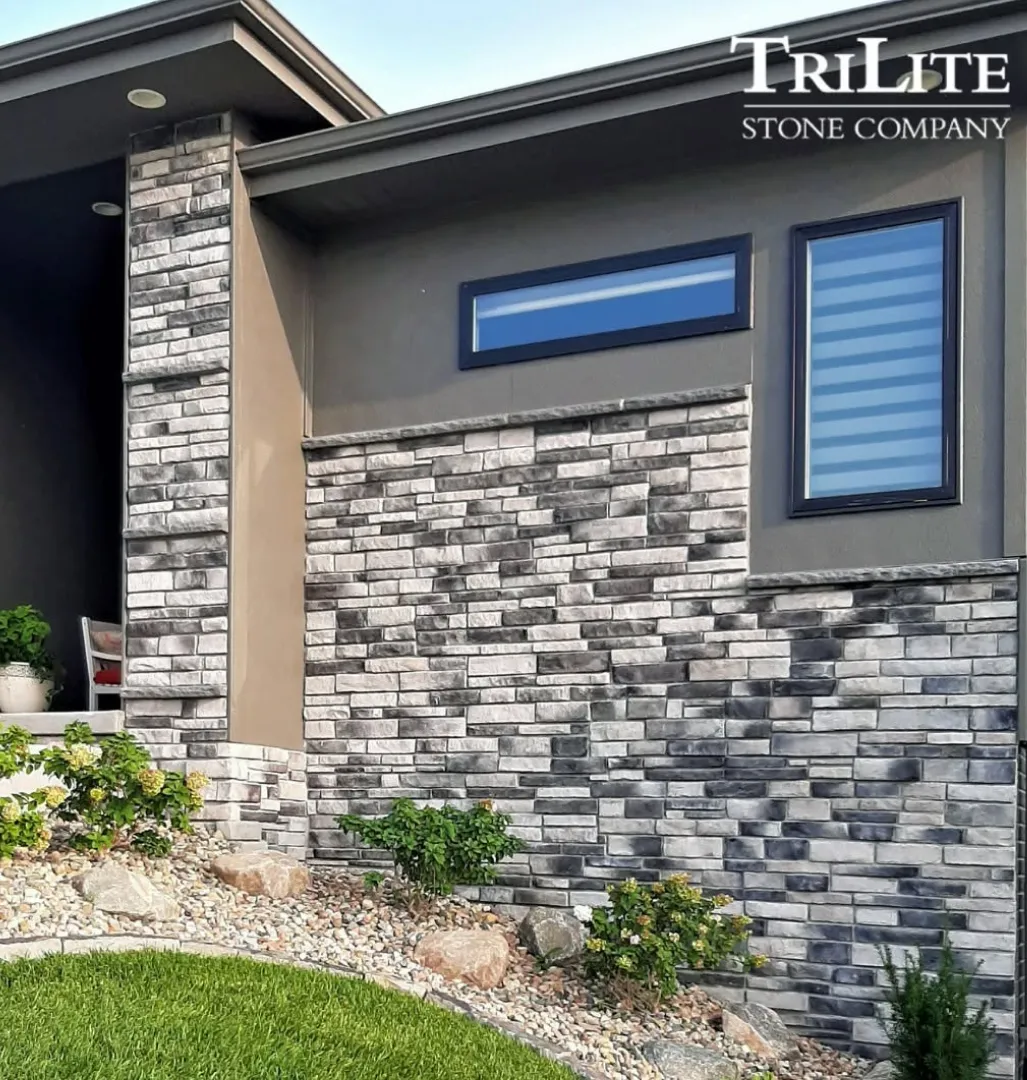 color-2 Modern home exterior with gray stone siding, landscaped yard, and TriLite Stone Company logo in the corner.