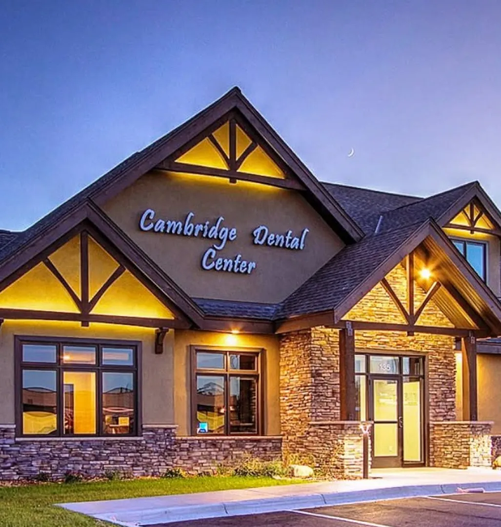 comm-2 Exterior of Cambridge Dental Center building at dusk with lights on and clear sky.