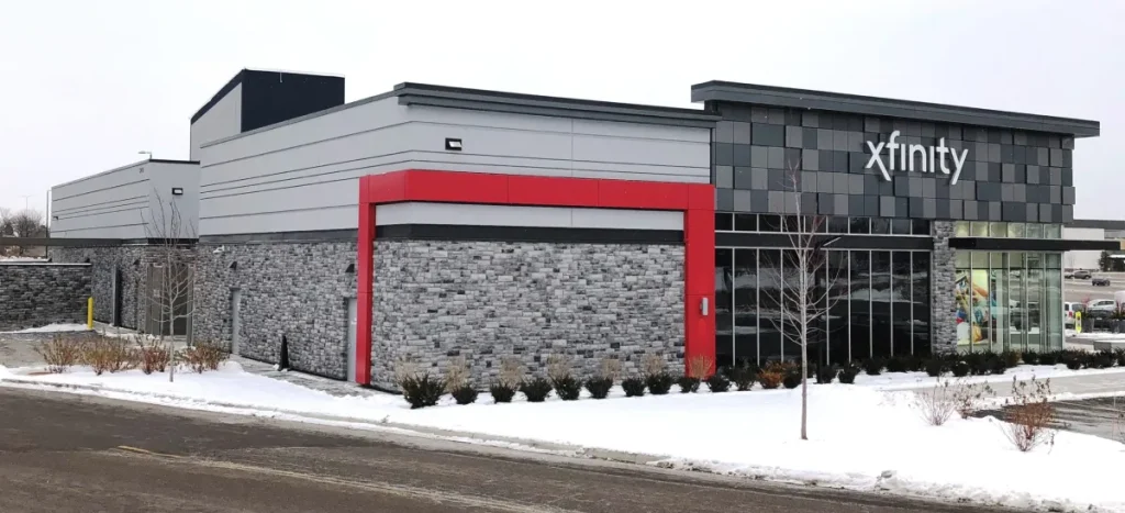 Modern Xfinity store building with stone siding and red trim, surrounded by snow in winter.