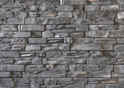 Gray stacked stone wall with various rectangular stones arranged in a horizontal pattern.