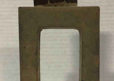 A square stone frame with a rectangular metal sheet inserted at the top against a white background.