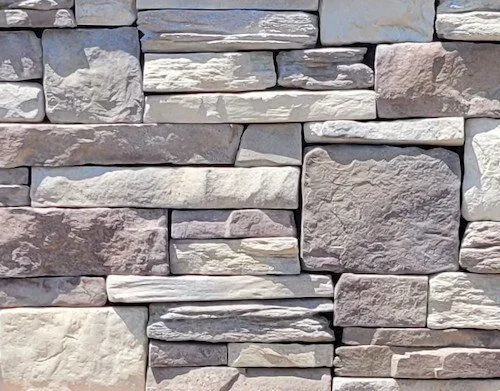 California-Blend-Northern-Creme Stacked stone wall with various sizes and shades of gray, beige, and tan rectangular stones.