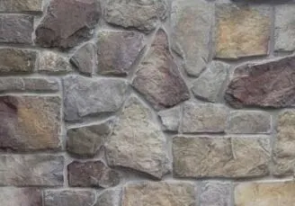 Country-Squire-Bucks-County Close-up of a stone wall with various shapes and colors of stones fitted together.