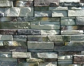 A close-up of a stone wall with unevenly stacked rectangular gray stones.