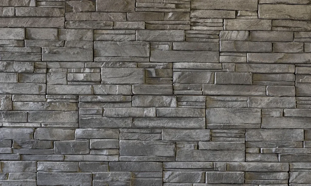 Gray stone brick wall with rectangular stones arranged in a horizontal, staggered pattern.