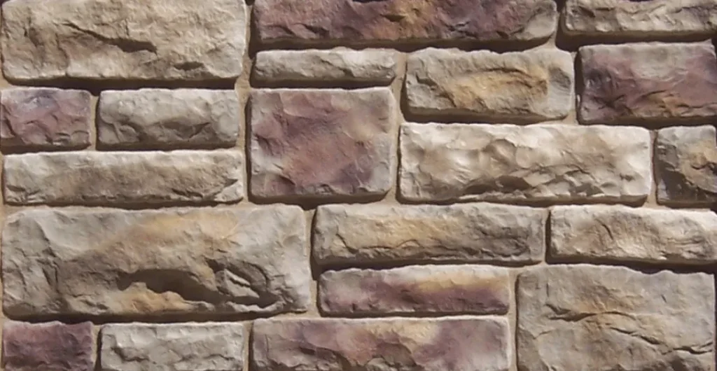 European-Limestone-Bucks-County Rectangular tan and brown stones arranged in a staggered brick pattern, resembling a stone wall.