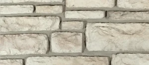 Light-colored stone wall with rectangular blocks arranged in an uneven, staggered pattern.
