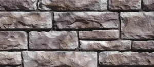 Gray stone wall with irregular rectangular stones arranged in a staggered pattern.