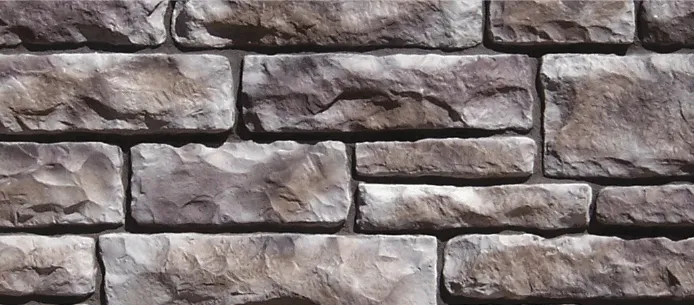 European-Limestone-Quartz Gray stone wall with irregular rectangular stones arranged in a staggered pattern.