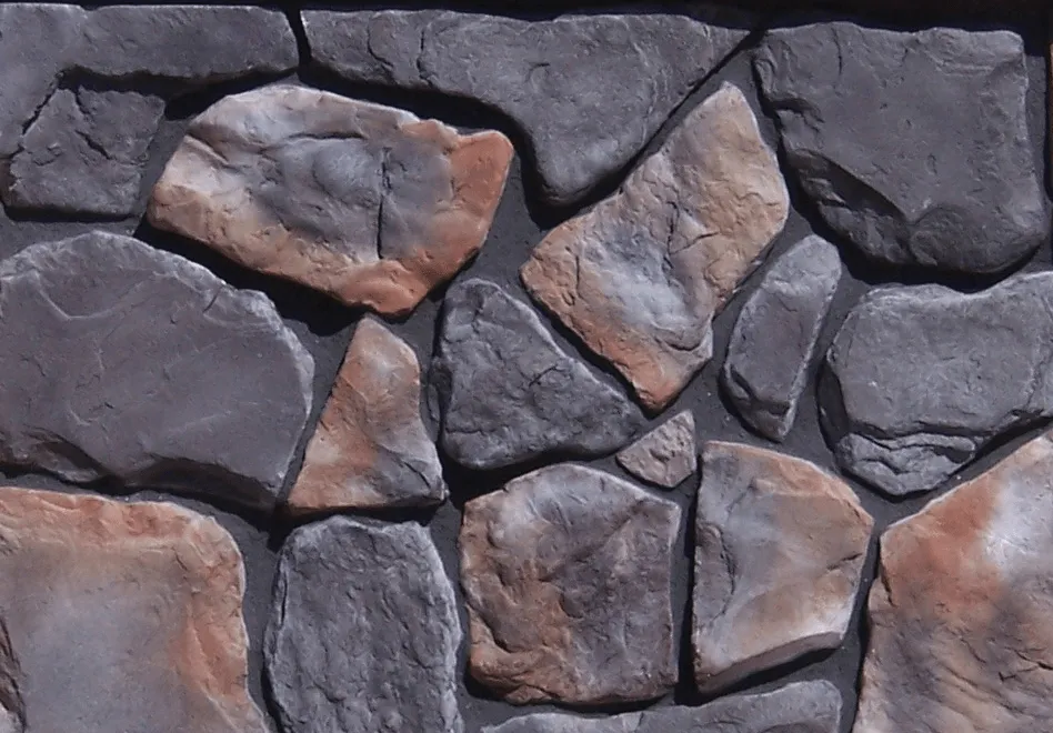 Fieldstone-Onyx Gray and brown irregular stones arranged in a pattern, resembling a stone wall or facade.