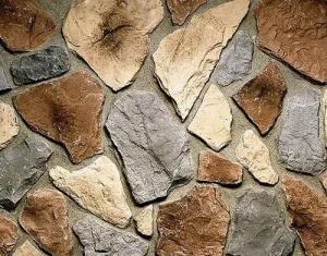 A close-up of an irregular stone wall with tan, brown, and gray stones set in mortar.