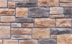 A wall made of rectangular beige and gray stone bricks arranged in a pattern.