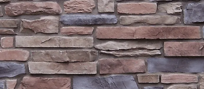 Mountain Ledge – Bucks County-2 A close-up of a stone brick wall with irregular shapes in shades of brown, tan, and gray.