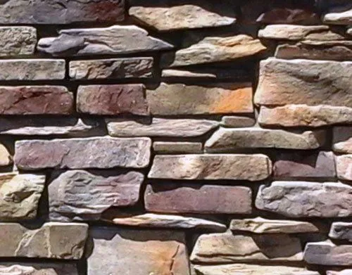 Mountain Ledge – Bucks County-3 A close-up of a textured stone wall with various rectangular stones in different earth tones.