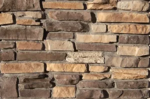 A close-up of a wall made of variously sized and colored rectangular stone bricks.