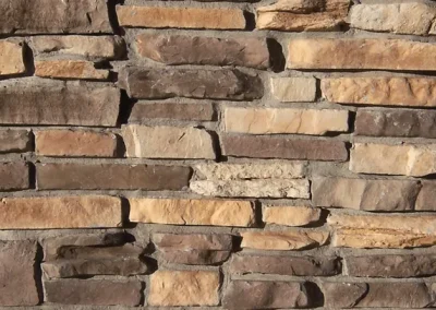 A close-up of a wall made of variously sized and colored rectangular stone bricks.