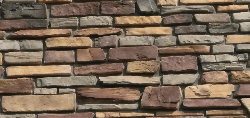 Mountain Ledge – Sierra Ridge A wall made of rectangular stones in various shades of brown, tan, and gray, stacked unevenly.