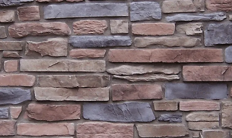 Mountain-Ledgestone-Buckskin Close-up of a wall made of rectangular stones in various shades of brown, gray, and tan.