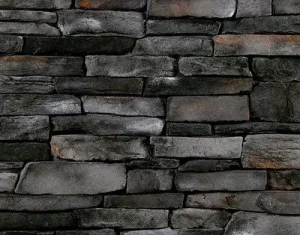 Dark gray stacked stone wall with uneven rectangular stones and rough textures.