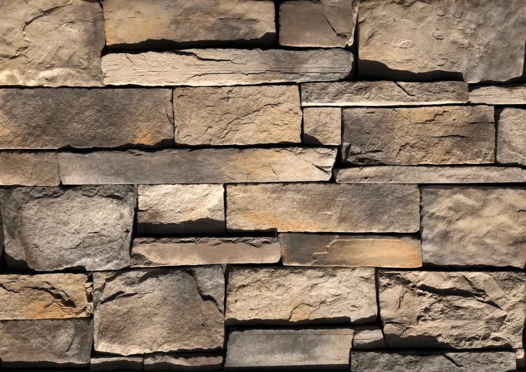 Quarry-Blend-Carmel Roughly stacked stone wall with various shades of brown and gray, featuring rectangular and uneven stones.